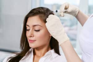 Beautiful woman getting hair loss treatment injections into her scalp for fuller, beautiful hair in Boise, ID